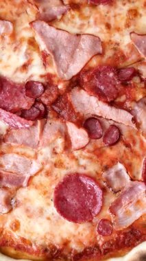 Peynirli ve salamlı İtalyan biberli pizza, domates ve sos. Fast food, dilimlenmiş pizza.