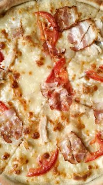 Tavuk ve pastırmalı İtalyan pizzası, peynir, domates ve sos. Fast food, dilimlenmiş pizza.