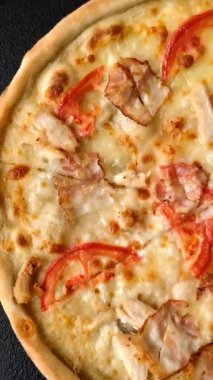 Tavuk ve pastırmalı İtalyan pizzası, peynir, domates ve sos. Fast food, dilimlenmiş pizza.