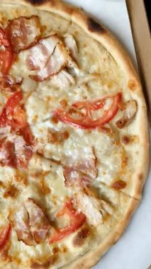 Tavuk ve pastırmalı İtalyan pizzası, peynir, domates ve sos. Fast food, dilimlenmiş pizza.