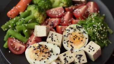Vejetaryen salatası, bezelyeli kase brokoli, domates, tofu peyniri ve haşlanmış yumurta. Sebzeli, tohumlu ve tahıllı vejetaryen yemeği