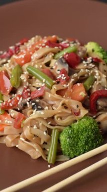 Çin ya da Tayland yemeği, etli, tuzlu ve baharatlı pirinç eriştesi. Arka plan olarak Asya yemekleri