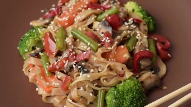 Çin ya da Tayland yemeği, etli, tuzlu ve baharatlı pirinç eriştesi. Arka plan olarak Asya yemekleri