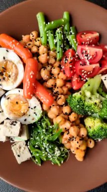 Vejetaryen salatası, bezelyeli kase brokoli, domates, tofu peyniri ve haşlanmış yumurta. Sebzeli, tohumlu ve tahıllı vejetaryen yemeği