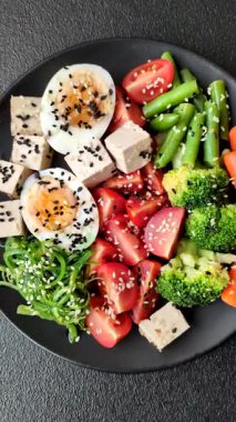 Vejetaryen salatası, bezelyeli kase brokoli, domates, tofu peyniri ve haşlanmış yumurta. Sebzeli, tohumlu ve tahıllı vejetaryen yemeği