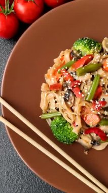 Çin ya da Tayland yemeği, etli, tuzlu ve baharatlı pirinç eriştesi. Arka plan olarak Asya yemekleri