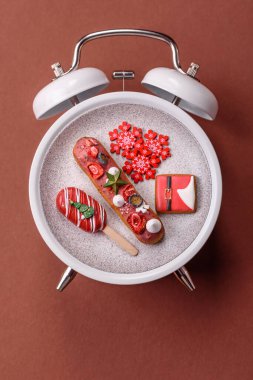 Noel, eski bir saatin üzerindeki bir tabakta tutulma. Noel zamanı kavramsal arka plan, şenlikli tatlılar ve pastalar