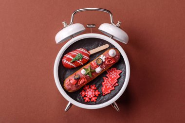 Noel, eski bir saatin üzerindeki bir tabakta tutulma. Noel zamanı kavramsal arka plan, şenlikli tatlılar ve pastalar