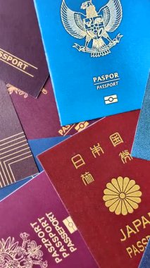 Farklı ülkelerin vatandaşlarının pasaportları, çeşitli ülkelerin pasaportlarından oluşan arka plan..