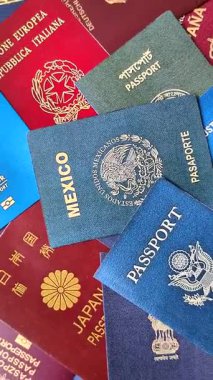Farklı ülkelerin vatandaşlarının pasaportları, çeşitli ülkelerin pasaportlarından oluşan arka plan..