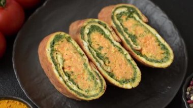 Bir rulo omlet, ıspanak, peynir ve kıyma. Yumurta ve ıspanakla yuvarlan.