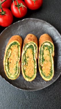 Bir rulo omlet, ıspanak, peynir ve kıyma. Yumurta ve ıspanakla yuvarlan.