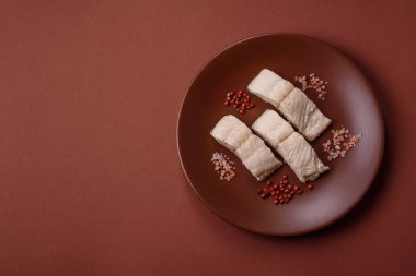 Beyaz balık filetosu, tuzlu ve baharatlı deniz ürünleri. Seramik tabakta balık fileto.