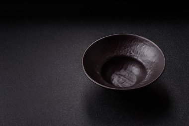 Yemek, risotto ya da makarna için boş yuvarlak siyah tabak yemek masasında mutfak gereçleri. Koyu arkaplanda boş tabak