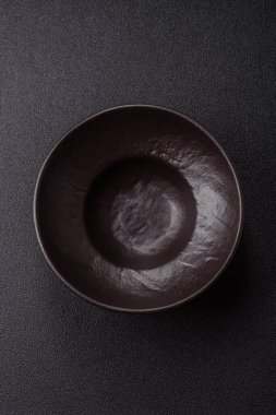 Yemek, risotto ya da makarna için boş yuvarlak siyah tabak yemek masasında mutfak gereçleri. Koyu arkaplanda boş tabak