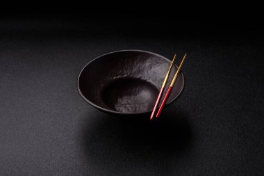 Yemek, risotto ya da makarna için boş yuvarlak siyah tabak yemek masasında mutfak gereçleri. Koyu arkaplanda boş tabak