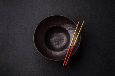 Yemek, risotto ya da makarna için boş yuvarlak siyah tabak yemek masasında mutfak gereçleri. Koyu arkaplanda boş tabak