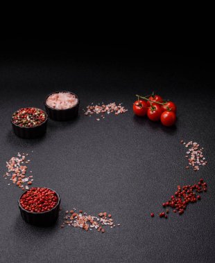 Koyu beton zeminde domates, tuz, baharat ve otlar pişirmek için gerekli malzemeler.