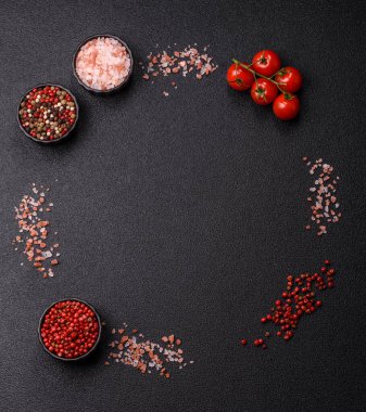 Koyu beton zeminde domates, tuz, baharat ve otlar pişirmek için gerekli malzemeler.