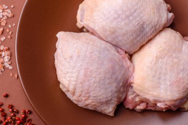 Et, çiğ tavuk budu, tuzlu ve baharatlı deri bacağı. Yemek arkaplanı olarak çiğ tavuk but eti.