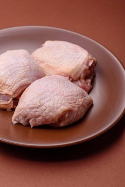 Et, çiğ tavuk budu, tuzlu ve baharatlı deri bacağı. Yemek arkaplanı olarak çiğ tavuk but eti.