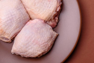 Et, çiğ tavuk budu, tuzlu ve baharatlı deri bacağı. Yemek arkaplanı olarak çiğ tavuk but eti.