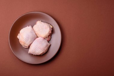 Et, çiğ tavuk budu, tuzlu ve baharatlı deri bacağı. Yemek arkaplanı olarak çiğ tavuk but eti.