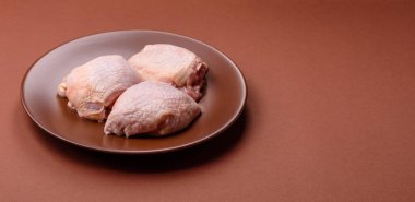 Et, çiğ tavuk budu, tuzlu ve baharatlı deri bacağı. Yemek arkaplanı olarak çiğ tavuk but eti.