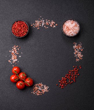 Koyu beton zeminde domates, tuz, baharat ve otlar pişirmek için gerekli malzemeler.