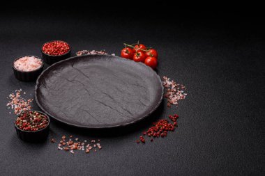 Yemek, risotto ya da makarna için boş yuvarlak siyah tabak yemek masasında mutfak gereçleri. Koyu arkaplanda boş tabak