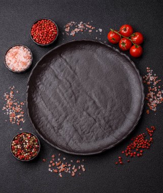 Yemek, risotto ya da makarna için boş yuvarlak siyah tabak yemek masasında mutfak gereçleri. Koyu arkaplanda boş tabak