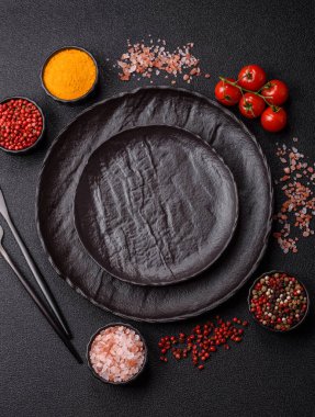 Yemek, risotto ya da makarna için boş yuvarlak siyah tabak yemek masasında mutfak gereçleri. Koyu arkaplanda boş tabak