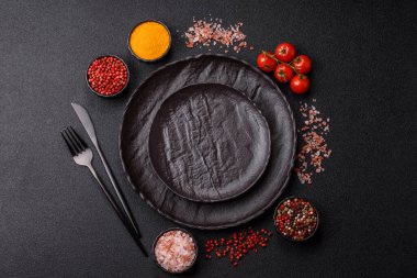 Yemek, risotto ya da makarna için boş yuvarlak siyah tabak yemek masasında mutfak gereçleri. Koyu arkaplanda boş tabak