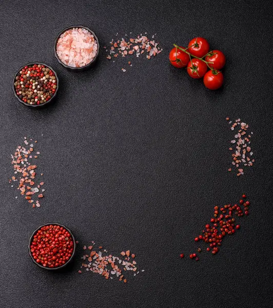 Koyu beton zeminde domates, tuz, baharat ve otlar pişirmek için gerekli malzemeler.