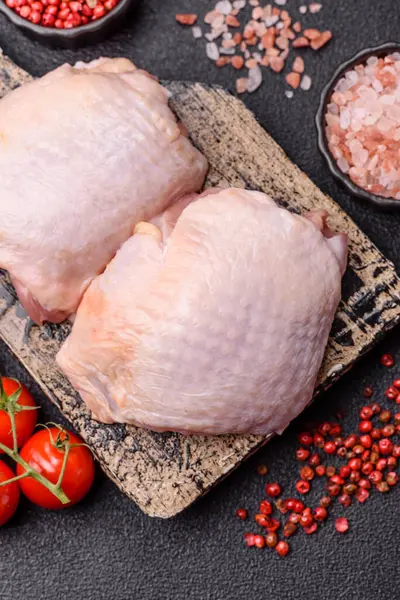 Et, çiğ tavuk budu, tuzlu ve baharatlı deri bacağı. Yemek arkaplanı olarak çiğ tavuk but eti.