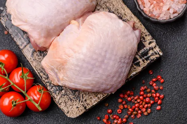 Et, çiğ tavuk budu, tuzlu ve baharatlı deri bacağı. Yemek arkaplanı olarak çiğ tavuk but eti.