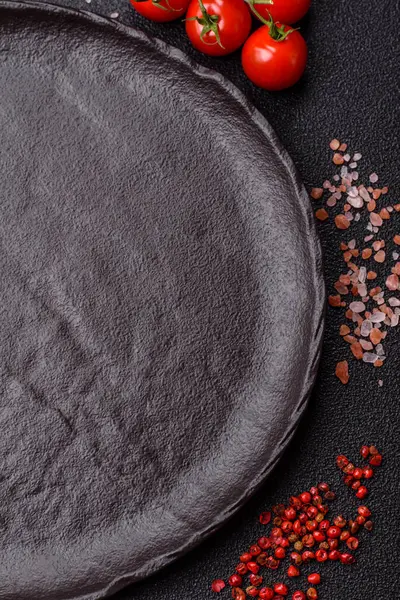 Yemek, risotto ya da makarna için boş yuvarlak siyah tabak yemek masasında mutfak gereçleri. Koyu arkaplanda boş tabak