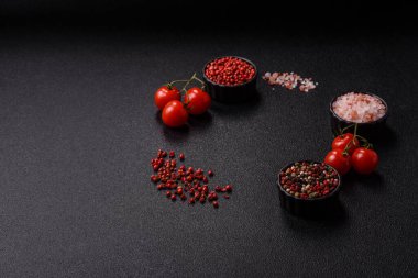 Koyu beton zeminde domates, tuz, baharat ve otlar pişirmek için gerekli malzemeler.