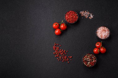 Koyu beton zeminde domates, tuz, baharat ve otlar pişirmek için gerekli malzemeler.