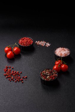 Koyu beton zeminde domates, tuz, baharat ve otlar pişirmek için gerekli malzemeler.