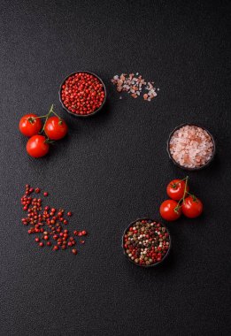 Koyu beton zeminde domates, tuz, baharat ve otlar pişirmek için gerekli malzemeler.