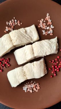 Beyaz balık filetosu, tuzlu ve baharatlı deniz ürünleri. Seramik tabakta balık fileto.