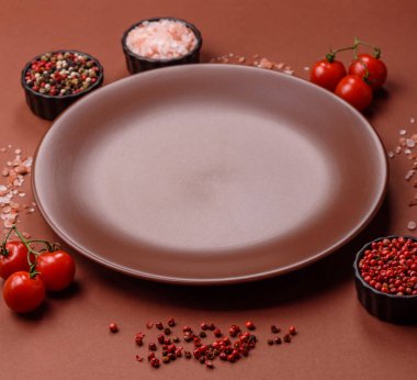 Tek renkli kahverengi arka planda boş seramik plaka. Yemek masasında çatal bıçak takımı olan boş bir tabak.