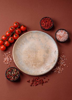 Yemek için boş yuvarlak siyah tabak, yemek masasında mutfak gereçleri. Koyu arkaplanda boş tabak