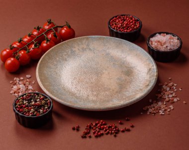 Yemek için boş yuvarlak siyah tabak, yemek masasında mutfak gereçleri. Koyu arkaplanda boş tabak