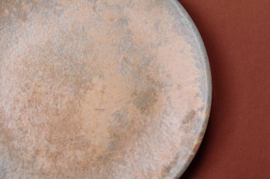 Yemek için boş yuvarlak siyah tabak, yemek masasında mutfak gereçleri. Koyu arkaplanda boş tabak