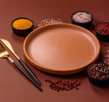 Yemek için boş yuvarlak siyah tabak, yemek masasında mutfak gereçleri. Koyu arkaplanda boş tabak