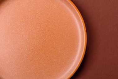 Yemek için boş yuvarlak siyah tabak, yemek masasında mutfak gereçleri. Koyu arkaplanda boş tabak