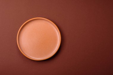 Yemek için boş yuvarlak siyah tabak, yemek masasında mutfak gereçleri. Koyu arkaplanda boş tabak