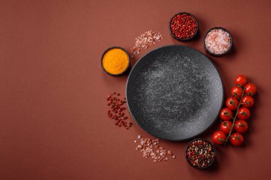 Yemek için boş yuvarlak siyah tabak, yemek masasında mutfak gereçleri. Koyu arkaplanda boş tabak